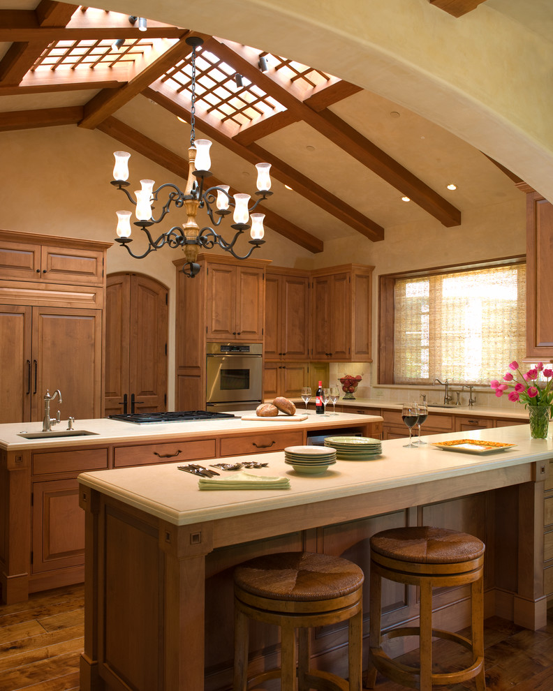 Exempel på ett mycket stort medelhavsstil kök, med luckor med upphöjd panel, skåp i mellenmörkt trä och integrerade vitvaror