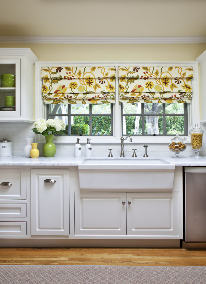 Exempel på ett mellanstort klassiskt vit vitt kök med öppen planlösning, med en rustik diskho, luckor med upphöjd panel, vita skåp, marmorbänkskiva, vitt stänkskydd, stänkskydd i tunnelbanekakel, rostfria vitvaror, mellanmörkt trägolv och brunt golv