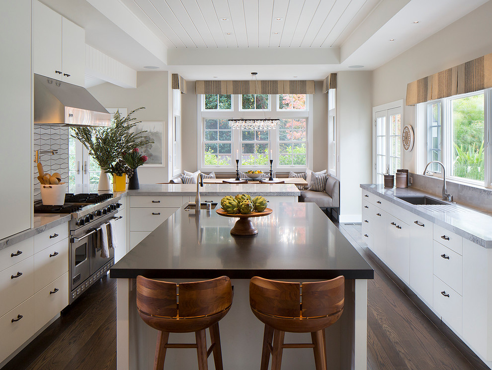 Example of a trendy dark wood floor eat-in kitchen design in San Francisco with an undermount sink, flat-panel cabinets, white cabinets, marble countertops, stainless steel appliances, an island and white backsplash