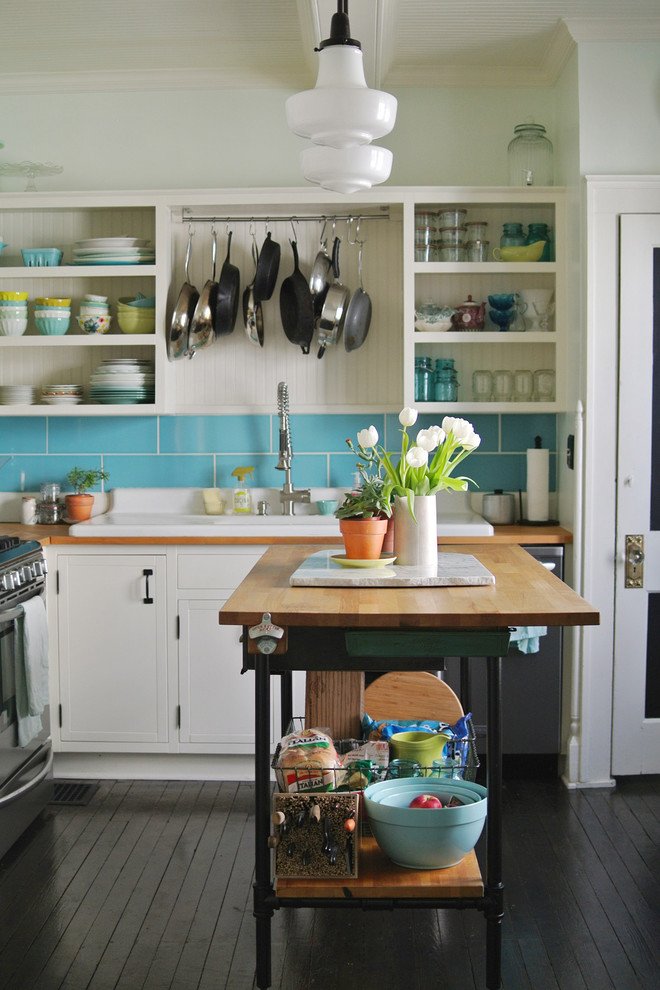 Inspiration for a country l-shaped dark wood floor enclosed kitchen remodel in Columbus with a drop-in sink, open cabinets, white cabinets, wood countertops, blue backsplash, subway tile backsplash, stainless steel appliances and an island