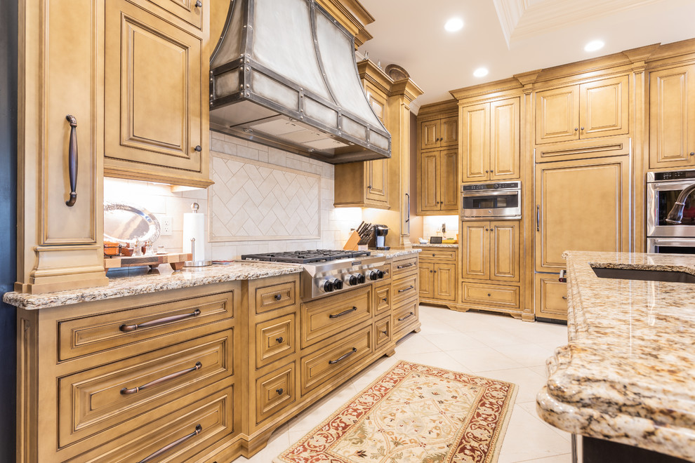 Design ideas for a large traditional u-shaped kitchen/diner in Other with a submerged sink, raised-panel cabinets, medium wood cabinets, granite worktops, beige splashback, ceramic splashback, integrated appliances, porcelain flooring, an island, beige floors and multicoloured worktops.