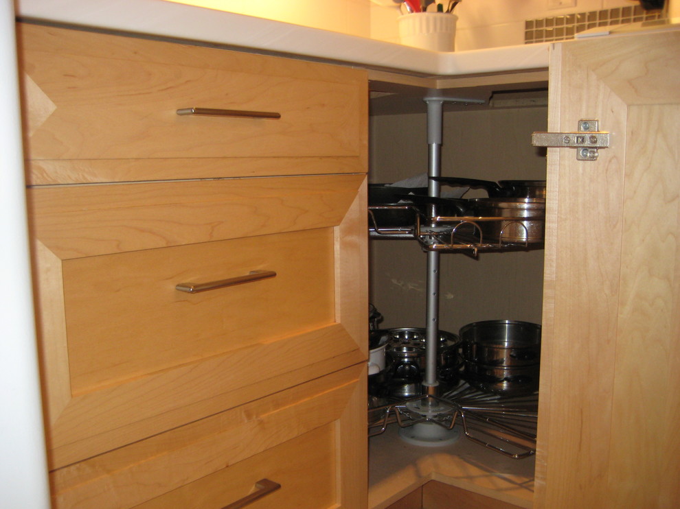 This is an example of a small traditional enclosed kitchen in Vancouver with a submerged sink, shaker cabinets, light wood cabinets, composite countertops, white splashback, ceramic splashback, white appliances, ceramic flooring and a breakfast bar.