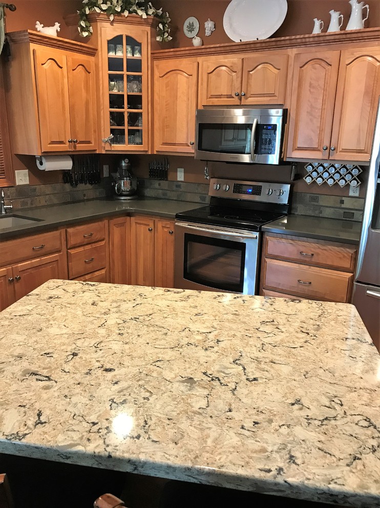 Photo of a medium sized classic l-shaped kitchen/diner in Other with a submerged sink, raised-panel cabinets, medium wood cabinets, engineered stone countertops, multi-coloured splashback, ceramic splashback, stainless steel appliances, medium hardwood flooring, an island and brown floors.