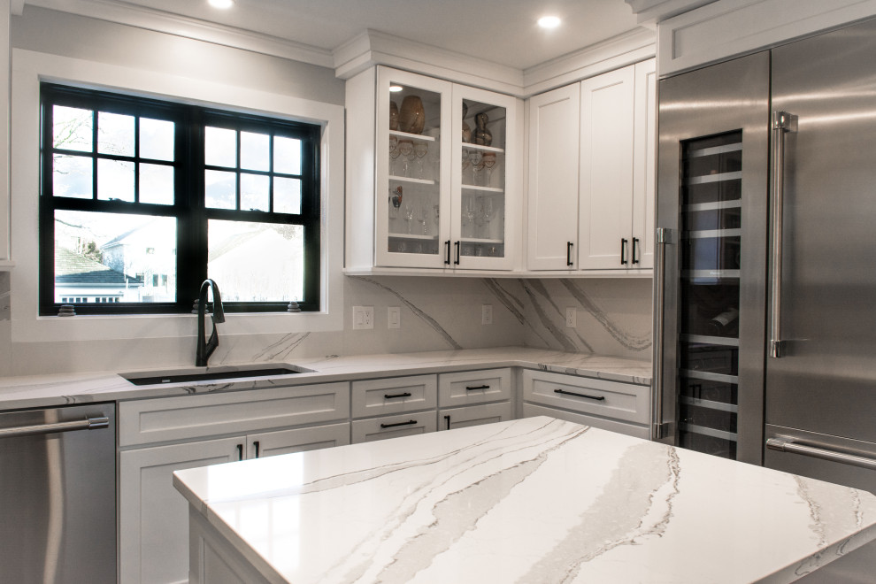 Inspiration for a mid-sized timeless u-shaped eat-in kitchen remodel in Providence with an undermount sink, shaker cabinets, white cabinets, quartz countertops, white backsplash, marble backsplash, stainless steel appliances, an island and white countertops