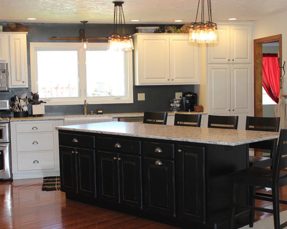 Example of a large mountain style l-shaped light wood floor open concept kitchen design in Chicago with a farmhouse sink, raised-panel cabinets, white cabinets, quartz countertops, stainless steel appliances and an island