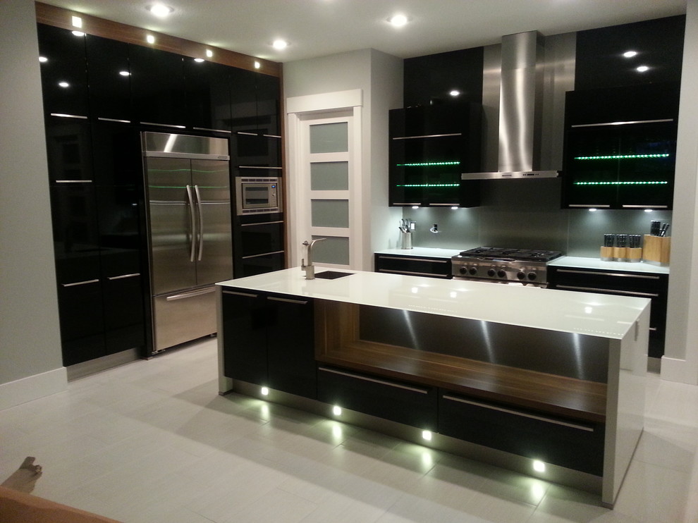 Zweizeilige Moderne Wohnküche mit Unterbauwaschbecken, flächenbündigen Schrankfronten, schwarzen Schränken, Glas-Arbeitsplatte, Küchenrückwand in Metallic und Küchengeräten aus Edelstahl in Edmonton