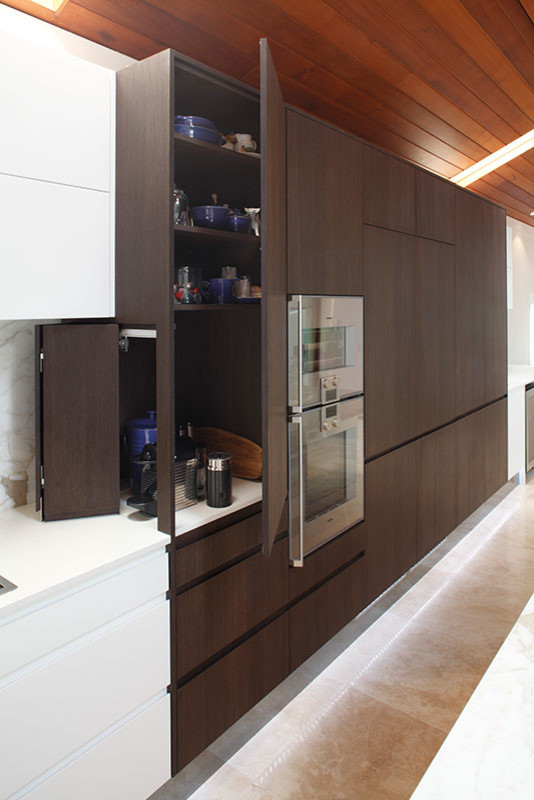 Design ideas for a large modern single-wall open plan kitchen in Sydney with a single-bowl sink, flat-panel cabinets, dark wood cabinets, marble worktops, multi-coloured splashback, mirror splashback, stainless steel appliances, travertine flooring and multiple islands.