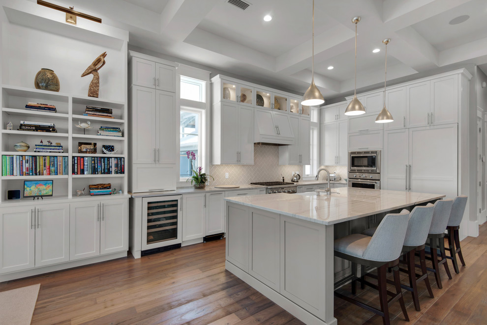Example of a large transitional single-wall medium tone wood floor and brown floor eat-in kitchen design in Miami with a farmhouse sink, shaker cabinets, white cabinets, marble countertops, white backsplash, ceramic backsplash, paneled appliances and an island