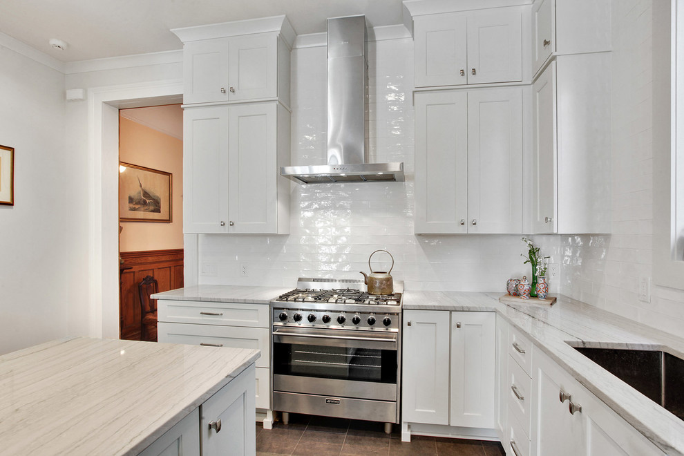 Inspiration for a large transitional l-shaped ceramic tile and brown floor kitchen remodel in New Orleans with an undermount sink, shaker cabinets, white cabinets, quartzite countertops, white backsplash, subway tile backsplash, stainless steel appliances, an island and white countertops