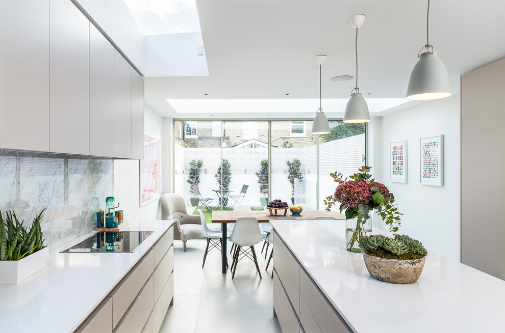 Moderne Wohnküche mit Unterbauwaschbecken, Keramikboden, Halbinsel, flächenbündigen Schrankfronten, weißen Schränken und weißem Boden in London