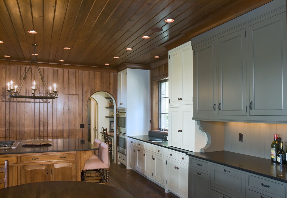 Modelo de cocina rústica de obra con fregadero bajoencimera, puertas de armario azules y electrodomésticos de acero inoxidable