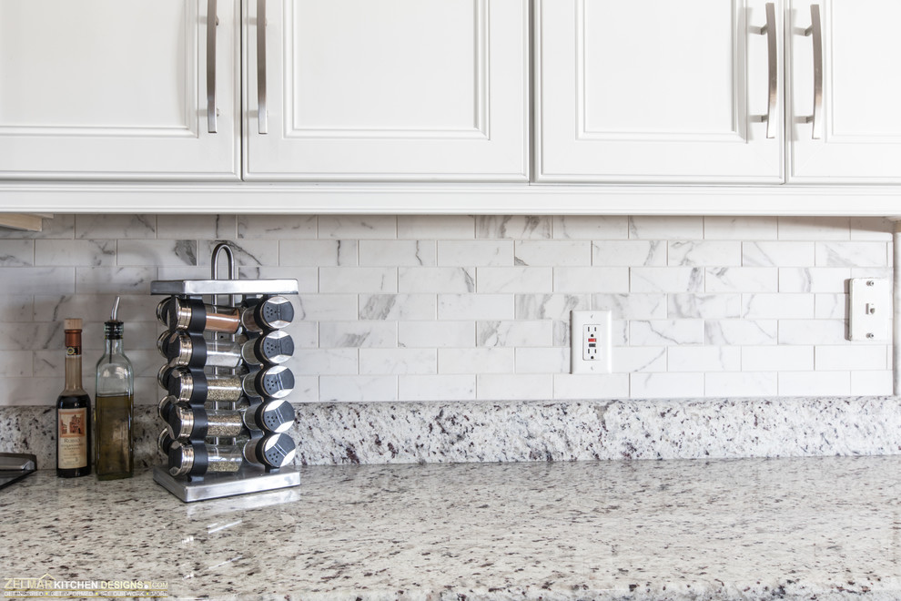 Klassisk inredning av ett mellanstort grå grått kök, med en undermonterad diskho, luckor med infälld panel, vita skåp, granitbänkskiva, vitt stänkskydd, stänkskydd i porslinskakel, klinkergolv i porslin och grått golv