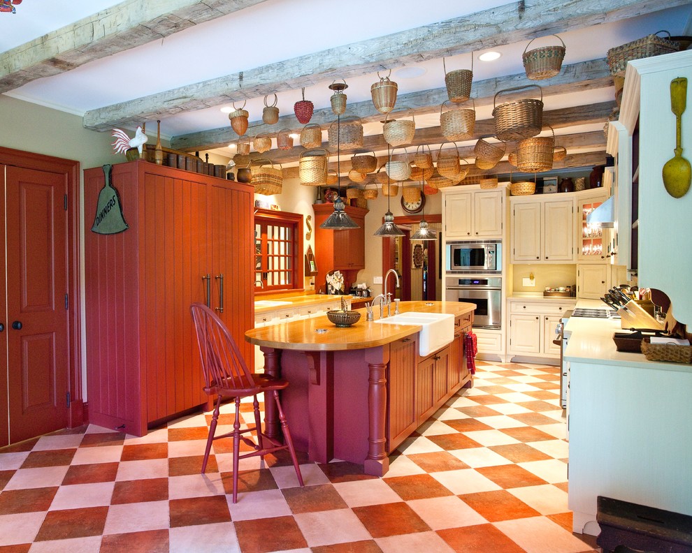 Exempel på ett avskilt lantligt kök, med en rustik diskho, luckor med upphöjd panel, röda skåp, träbänkskiva, rostfria vitvaror, klinkergolv i keramik och en köksö