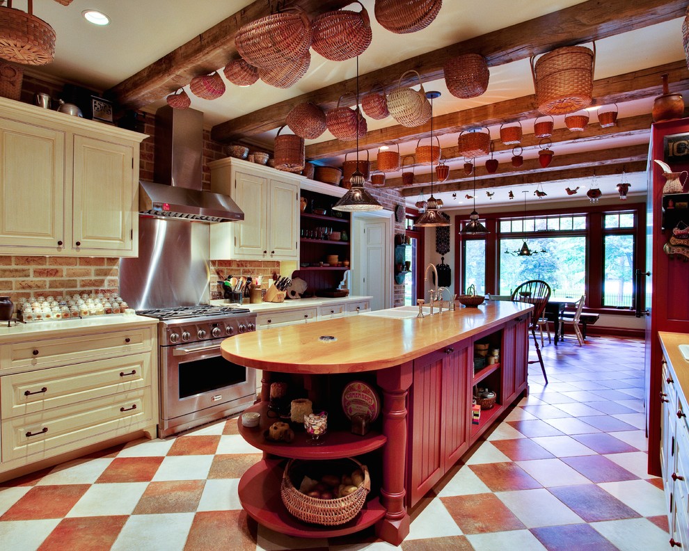 Inredning av ett lantligt stort kök och matrum, med en rustik diskho, luckor med upphöjd panel, beige skåp, träbänkskiva, rostfria vitvaror, klinkergolv i keramik, en köksö och stänkskydd med metallisk yta