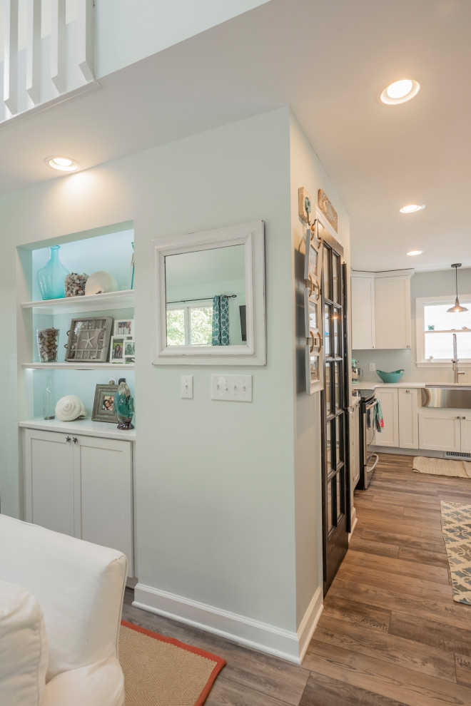 Example of a mid-sized beach style l-shaped vinyl floor open concept kitchen design in Other with a farmhouse sink, recessed-panel cabinets, white cabinets, granite countertops, stainless steel appliances and white countertops