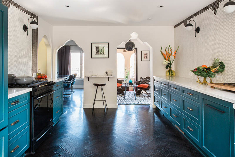 Example of a small eclectic galley dark wood floor enclosed kitchen design in San Francisco with a farmhouse sink, flat-panel cabinets, blue cabinets, marble countertops, white backsplash, ceramic backsplash, paneled appliances and white countertops