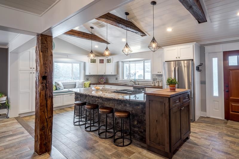 Ejemplo de cocina grande con encimera de madera, salpicadero verde, electrodomésticos de acero inoxidable, suelo de madera en tonos medios y una isla