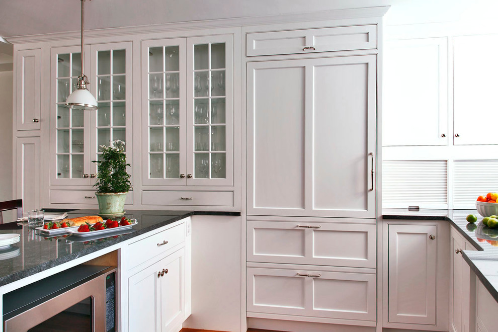 Modelo de cocina tradicional de tamaño medio con armarios con paneles lisos, puertas de armario blancas, encimera de granito, electrodomésticos de acero inoxidable y península