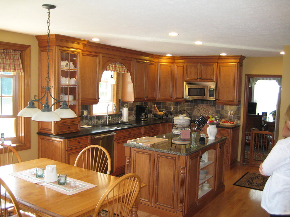 Mittelgroße Klassische Wohnküche in L-Form mit Unterbauwaschbecken, profilierten Schrankfronten, hellbraunen Holzschränken, Granit-Arbeitsplatte, Küchengeräten aus Edelstahl und braunem Holzboden in Boston