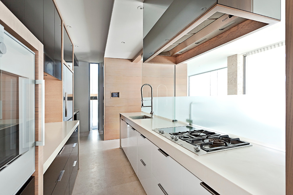 Immagine di una cucina parallela design chiusa con lavello sottopiano, ante lisce, ante nere, elettrodomestici da incasso e penisola