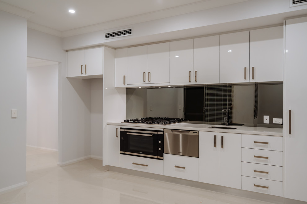 Exempel på ett mellanstort modernt kök, med en dubbel diskho, vita skåp, bänkskiva i kvartsit, stänkskydd med metallisk yta, glaspanel som stänkskydd, rostfria vitvaror, en köksö och klinkergolv i porslin