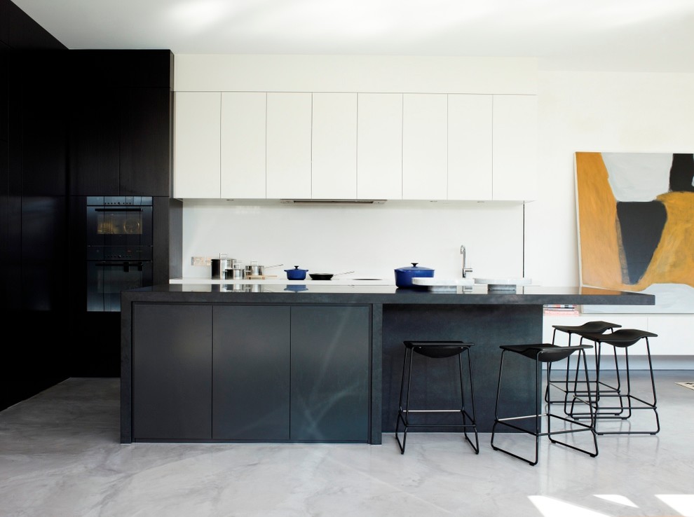 Imagen de cocina contemporánea con armarios con paneles lisos, salpicadero blanco, una isla y con blanco y negro