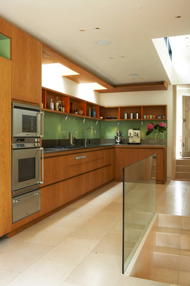 На фото: угловая кухня среднего размера в стиле модернизм с обеденным столом и светлыми деревянными фасадами без острова с