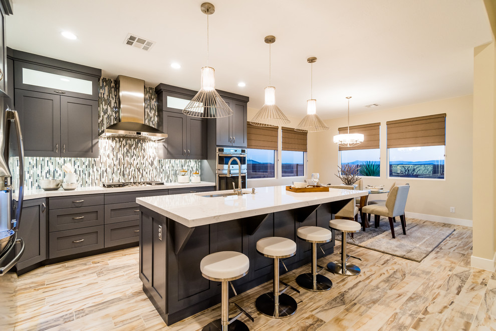 Photo of a medium sized contemporary l-shaped enclosed kitchen in Salt Lake City with a submerged sink, shaker cabinets, grey cabinets, marble worktops, multi-coloured splashback, mosaic tiled splashback, stainless steel appliances, light hardwood flooring and an island.