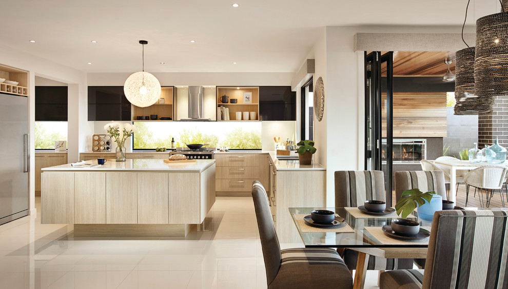 Foto di un cucina con isola centrale stile marinaro con ante a filo, elettrodomestici in acciaio inossidabile e pavimento in gres porcellanato