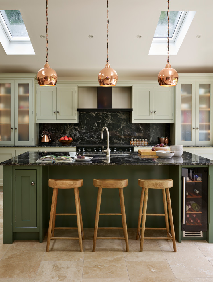 Foto på ett stort vintage linjärt kök med öppen planlösning, med gröna skåp, granitbänkskiva, svart stänkskydd, rostfria vitvaror och en köksö