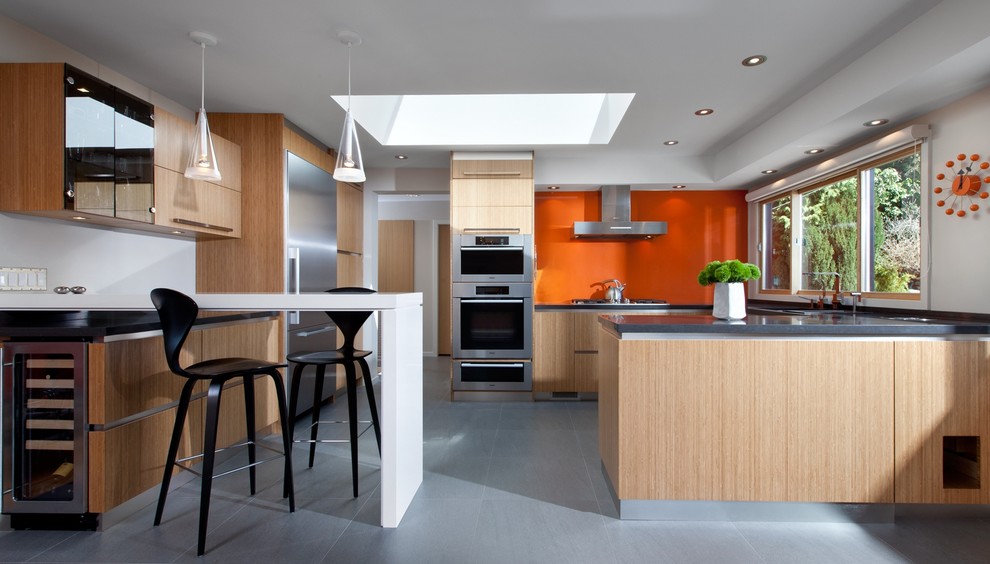 Esempio di una cucina contemporanea con ante lisce, ante in legno chiaro, top in quarzo composito, paraspruzzi arancione e elettrodomestici in acciaio inossidabile