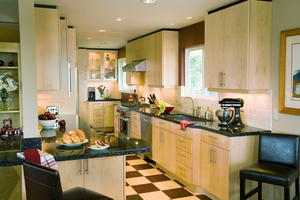 Zweizeilige Moderne Wohnküche mit Unterbauwaschbecken, flächenbündigen Schrankfronten, hellen Holzschränken, Granit-Arbeitsplatte, Küchenrückwand in Weiß, Rückwand aus Keramikfliesen und Küchengeräten aus Edelstahl in Portland