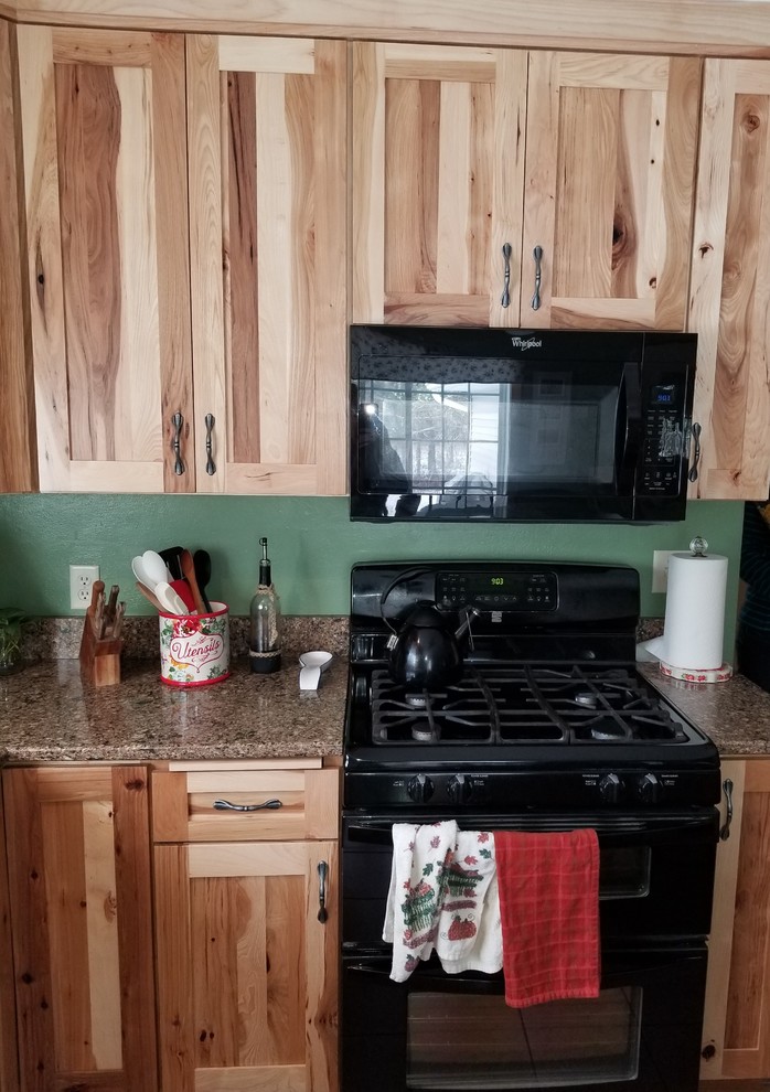 Foto på ett rustikt kök, med en undermonterad diskho, skåp i shakerstil, svarta vitvaror och en köksö