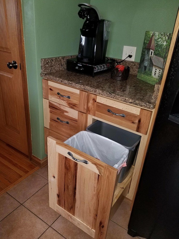 Cette image montre une cuisine chalet avec un évier encastré, un placard à porte shaker, un électroménager noir et îlot.
