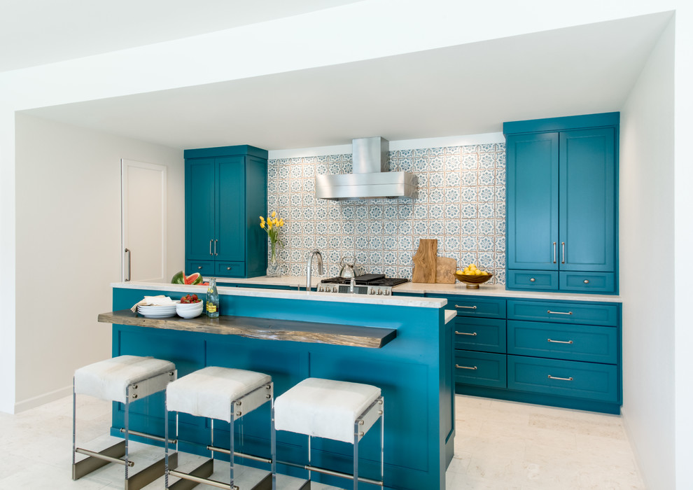 Modelo de cocina clásica renovada con armarios con paneles empotrados, puertas de armario azules, una isla, suelo beige y encimeras blancas