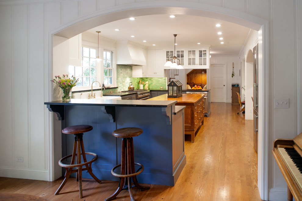Photo of a medium sized country u-shaped kitchen/diner in Los Angeles with a belfast sink, shaker cabinets, grey cabinets, soapstone worktops, green splashback, ceramic splashback, stainless steel appliances, medium hardwood flooring and an island.