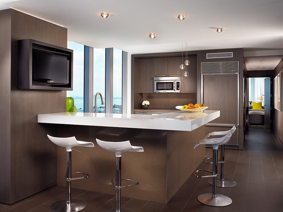 Imagen de cocina actual con armarios con paneles lisos, puertas de armario de madera en tonos medios, salpicadero marrón y electrodomésticos con paneles