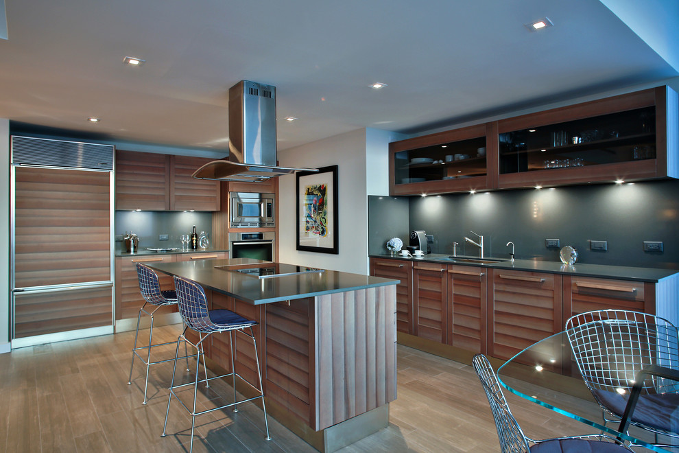 Photo of a large contemporary l-shaped kitchen/diner in Miami with a submerged sink, glass-front cabinets, grey splashback, integrated appliances, medium wood cabinets, engineered stone countertops, porcelain flooring and an island.
