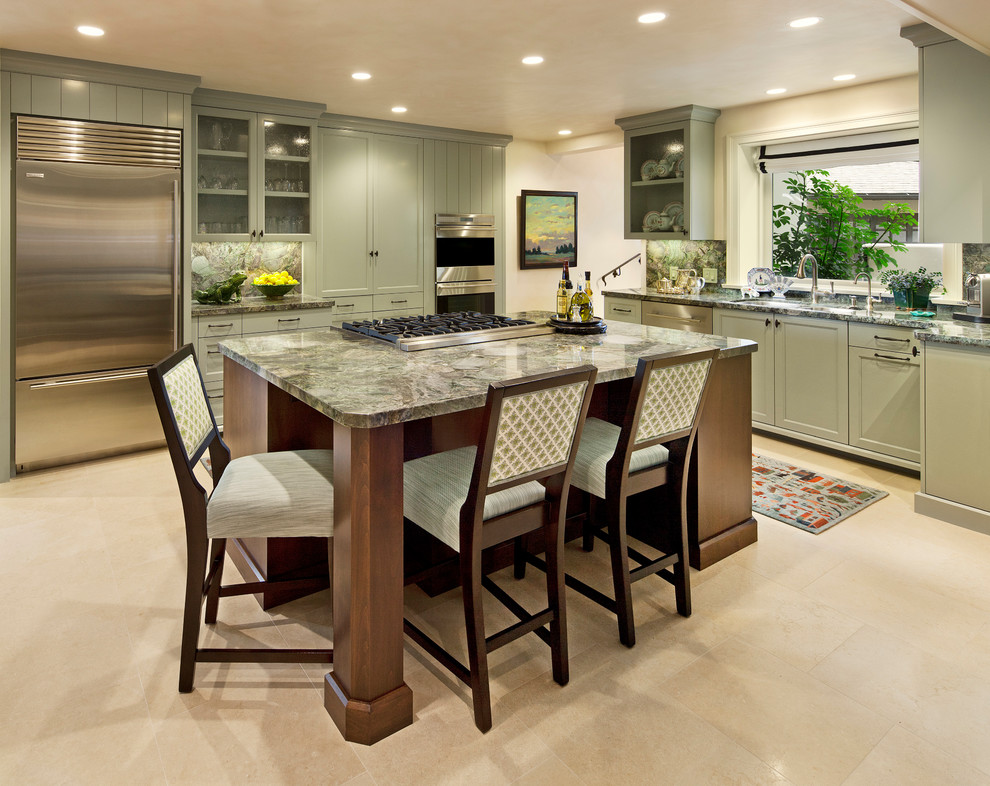 This is an example of a traditional kitchen in Santa Barbara with green cabinets, a submerged sink, recessed-panel cabinets, granite worktops, green splashback, stone slab splashback, stainless steel appliances, limestone flooring and an island.