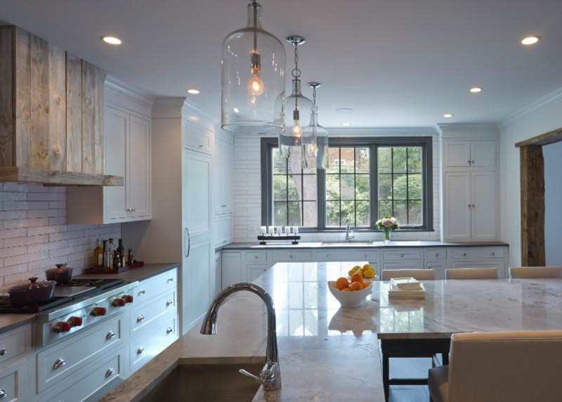 Bild på ett mellanstort lantligt kök och matrum, med en nedsänkt diskho, luckor med infälld panel, vita skåp, marmorbänkskiva, vitt stänkskydd, stänkskydd i keramik, rostfria vitvaror, klinkergolv i porslin, brunt golv och en köksö