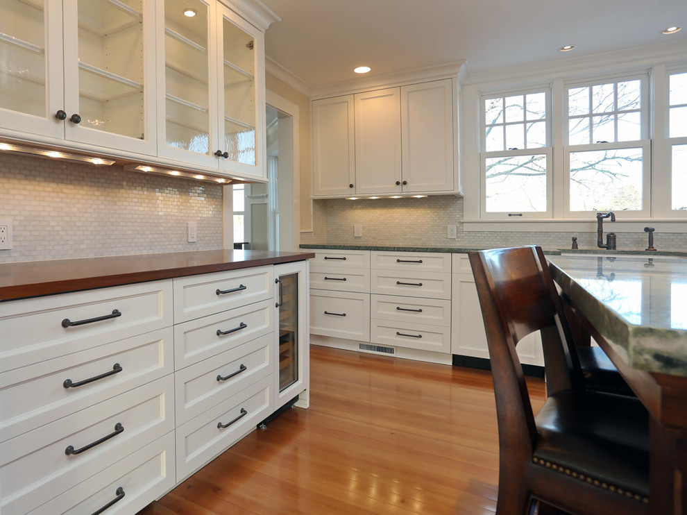 Inspiration for a coastal kitchen remodel in Boston with shaker cabinets, white cabinets, granite countertops, gray backsplash, mosaic tile backsplash and stainless steel appliances