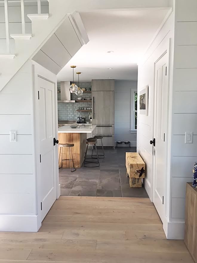 Example of a mid-sized beach style l-shaped eat-in kitchen design in Boston with flat-panel cabinets, light wood cabinets, quartzite countertops, gray backsplash, glass tile backsplash, stainless steel appliances and an island