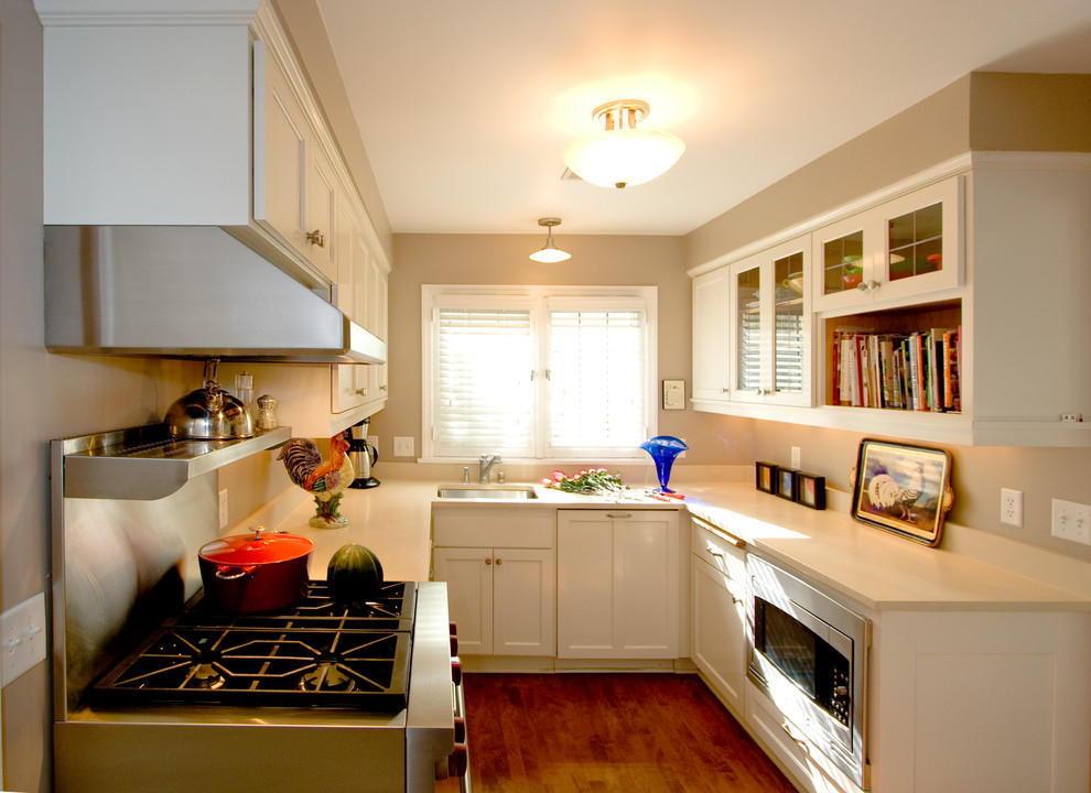 Idéer för att renovera ett avskilt, litet vintage u-kök, med en undermonterad diskho, skåp i shakerstil, gula skåp, bänkskiva i kvarts, rostfria vitvaror, mellanmörkt trägolv och brunt golv