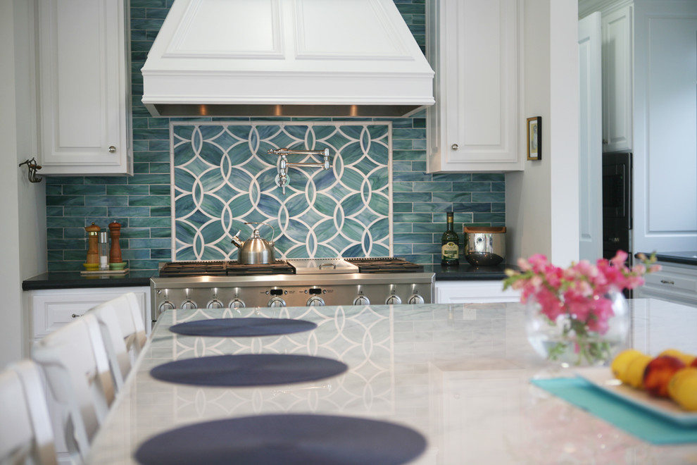 Inspiration for a large timeless l-shaped medium tone wood floor open concept kitchen remodel in Los Angeles with raised-panel cabinets, white cabinets, blue backsplash, stainless steel appliances, a farmhouse sink, quartz countertops, porcelain backsplash and an island
