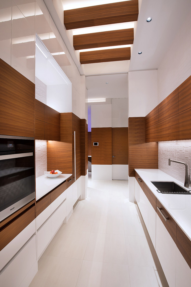 Diseño de cocina contemporánea con armarios con paneles lisos, puertas de armario de madera oscura y encimera de cuarcita