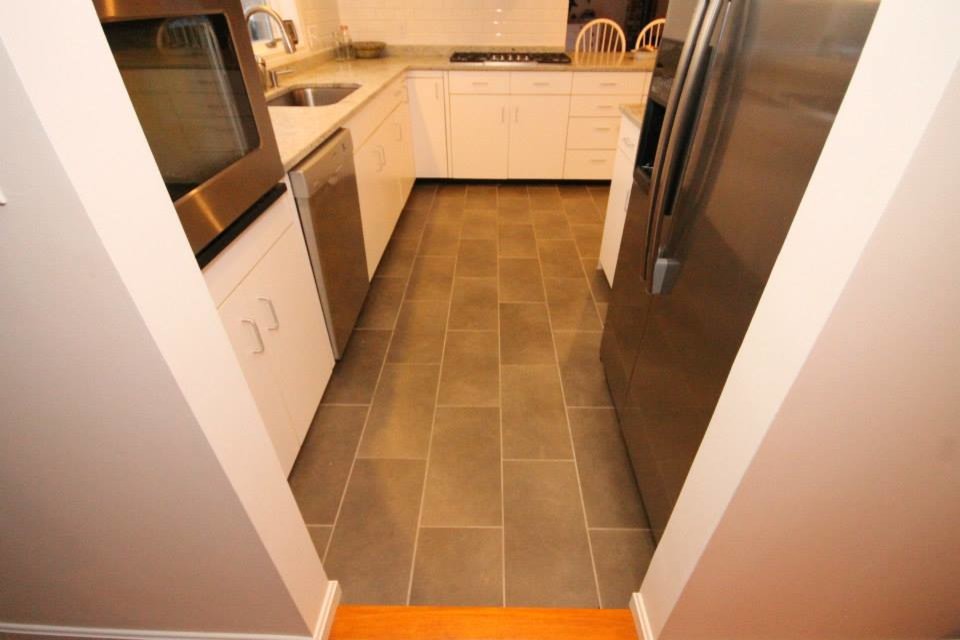 Example of a large trendy u-shaped enclosed kitchen design in Portland Maine with an undermount sink, flat-panel cabinets, white cabinets, granite countertops, white backsplash, subway tile backsplash, stainless steel appliances and two islands