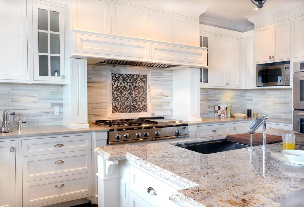 This is an example of a large classic u-shaped kitchen/diner in Vancouver with stainless steel appliances, white cabinets, engineered stone countertops, a submerged sink, beaded cabinets, grey splashback, medium hardwood flooring, an island and marble splashback.