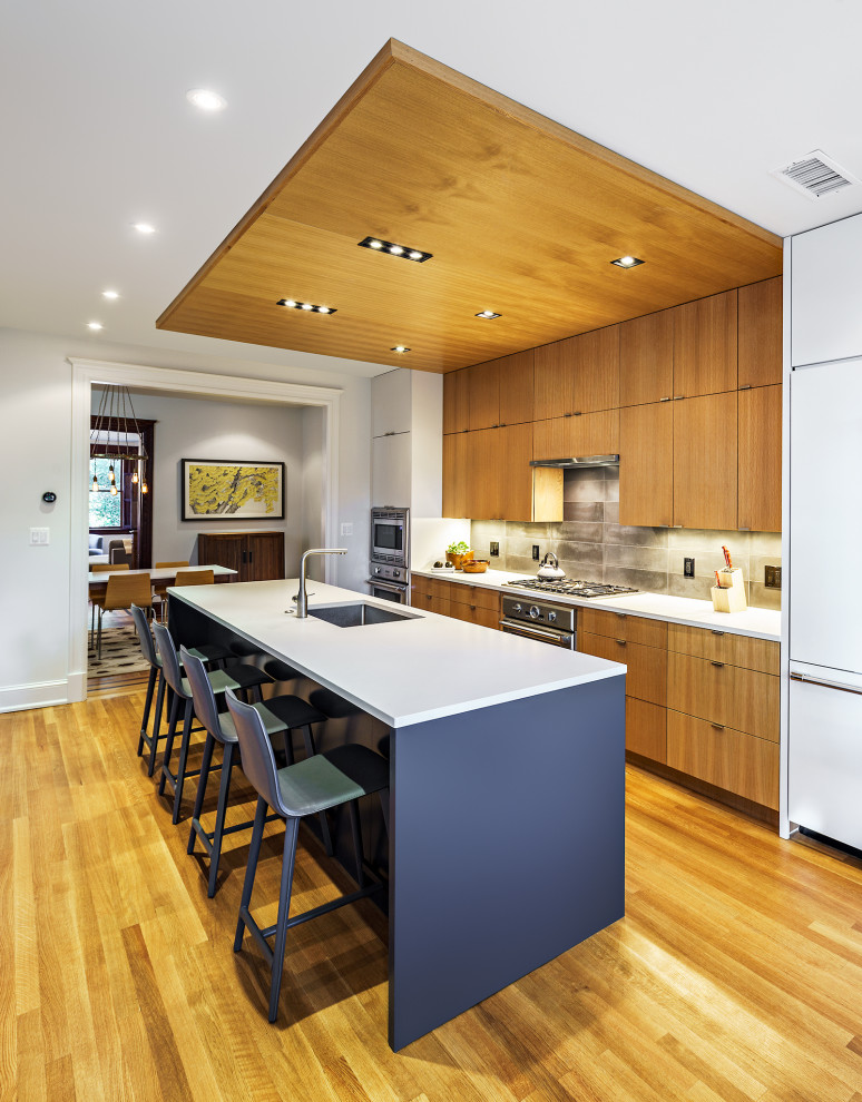 Moderne Küche mit hellbraunen Holzschränken, Quarzwerkstein-Arbeitsplatte und Kücheninsel in Washington, D.C.
