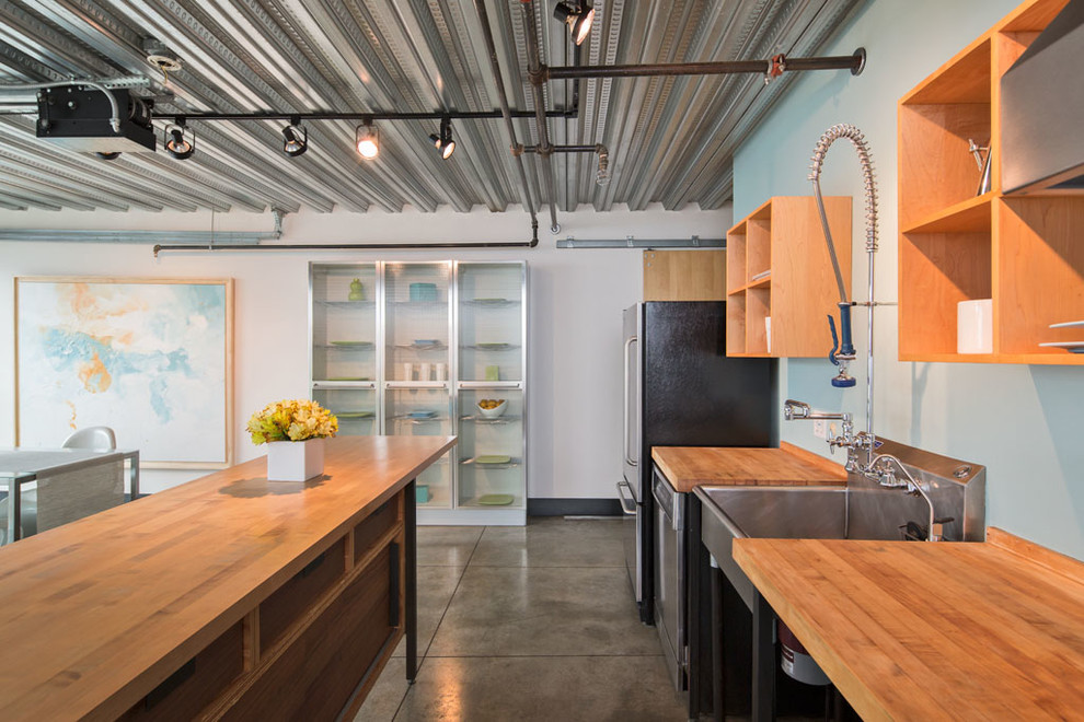Industrial Küche mit Waschbecken, Küchengeräten aus Edelstahl und Betonboden in Seattle