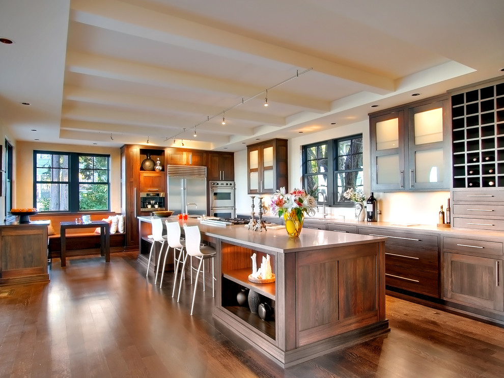 Example of a large trendy l-shaped dark wood floor eat-in kitchen design in Seattle with glass-front cabinets, dark wood cabinets, white backsplash, stainless steel appliances, an undermount sink and an island